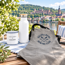 Heidelberg Koordinate Camper Mug, Ruder-Club Grillschürze und Panorama-Isolierflasche auf einem Tisch am Neckar